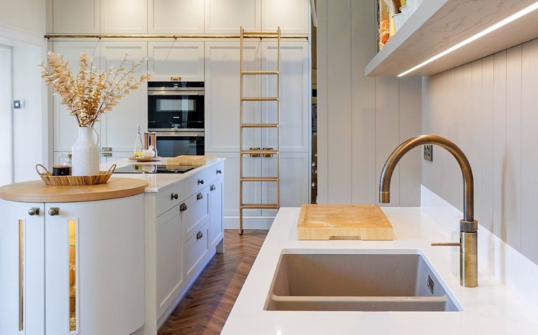 gold and white kitchen with gold library ladder