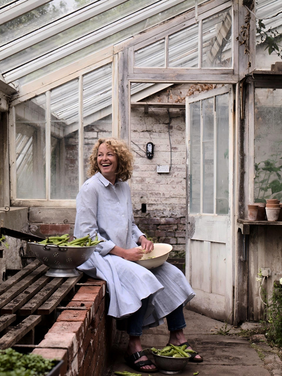 kate humble, gardener and TV presenter in her garden greenhouse at home