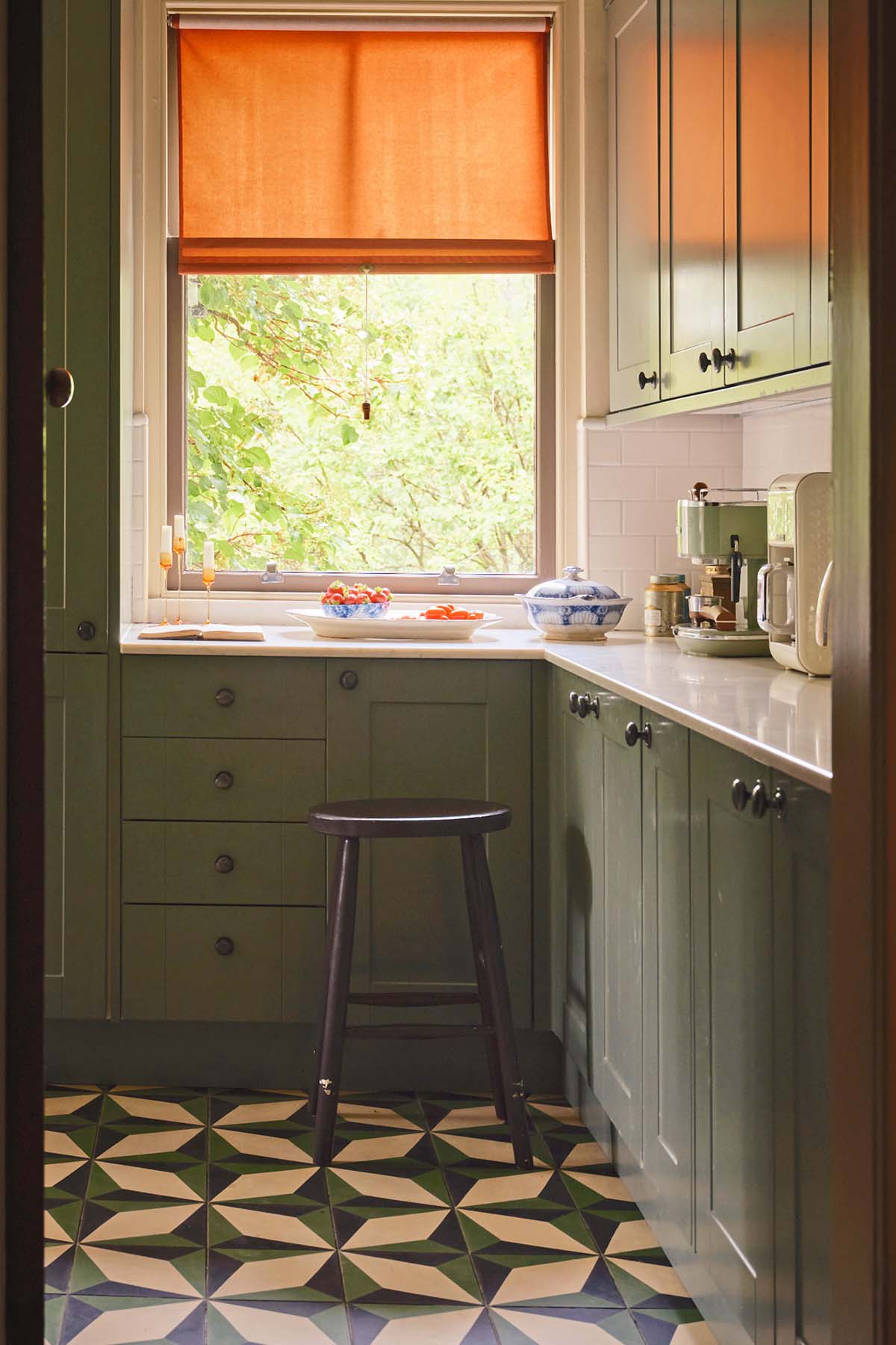 kitchen of ardlinnhe house, geometric tiling with orange blinds and mossy green cabinetry - listed by inigo