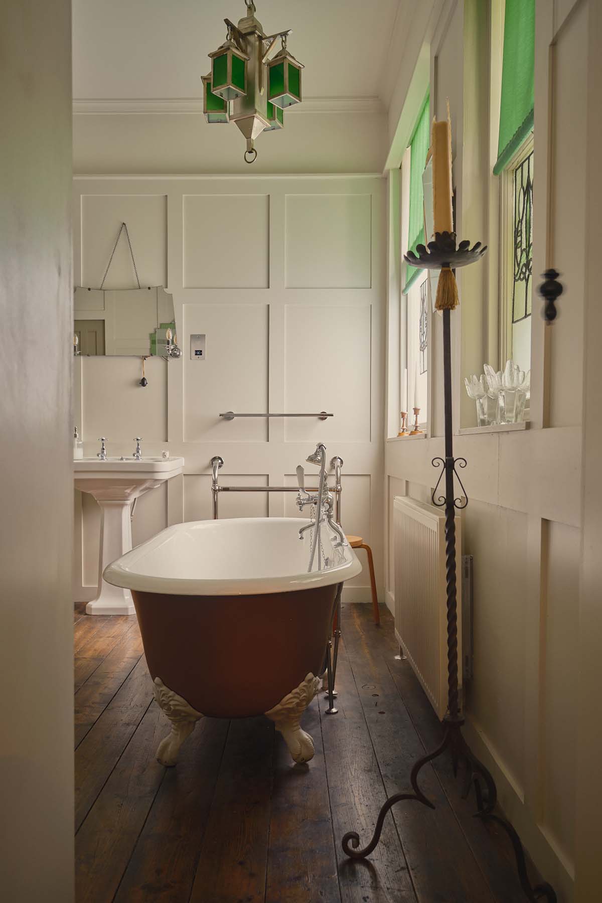 bathroom in Ardlinnhe house with red tub and dark original wooden flooring, light walls and plenty of natural light