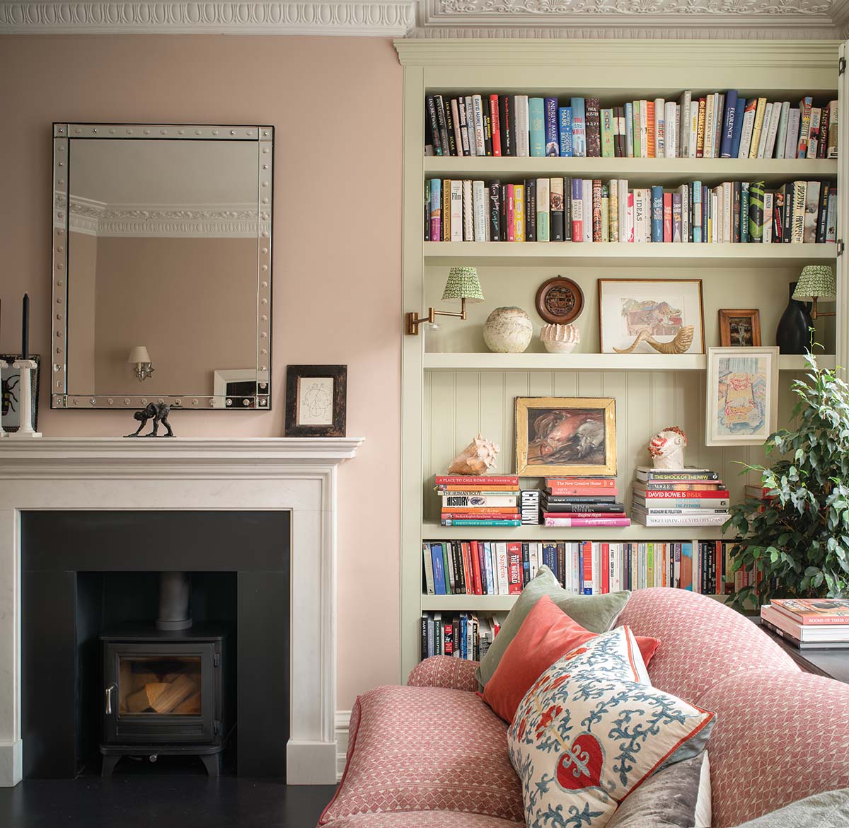 book case in cottage-like home inspired by nature and featuring floral soft furnishings and pale colour scheme of pastel pink and green designed by Jessica Buckley