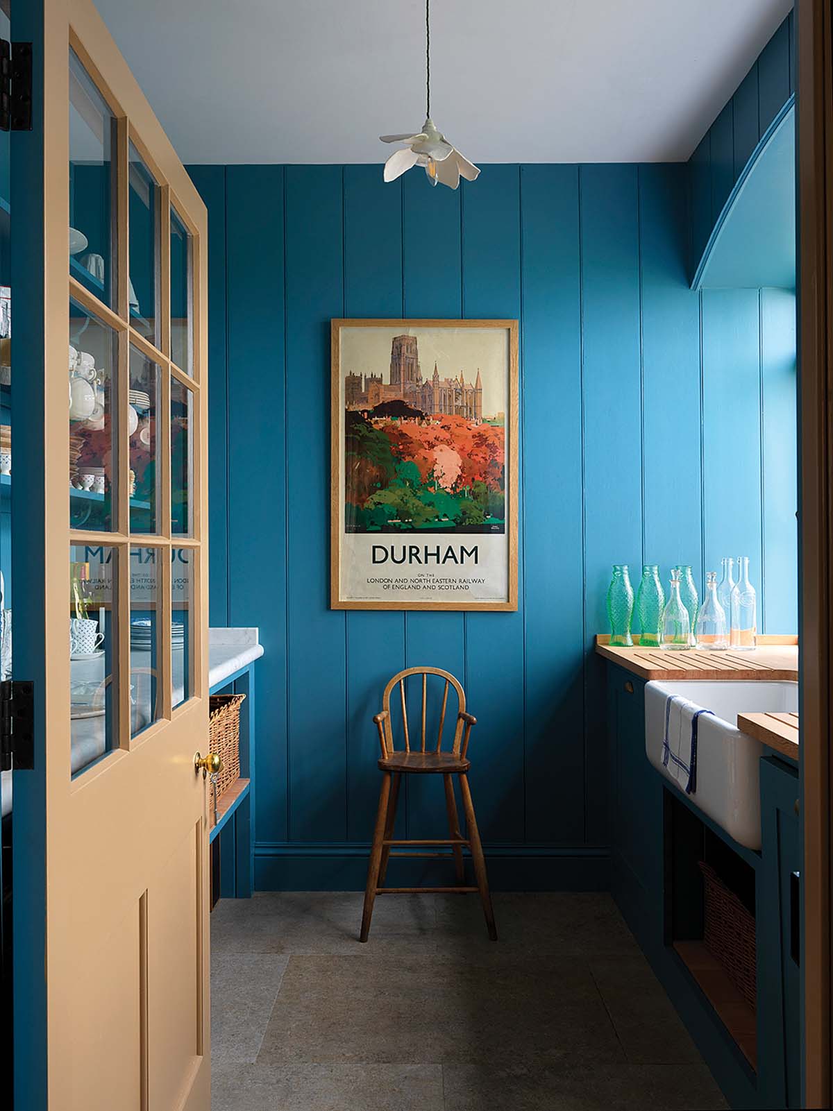 North farm in durham interior photo of the en suite, which is doused in blue paint with orange prints and light oak wood