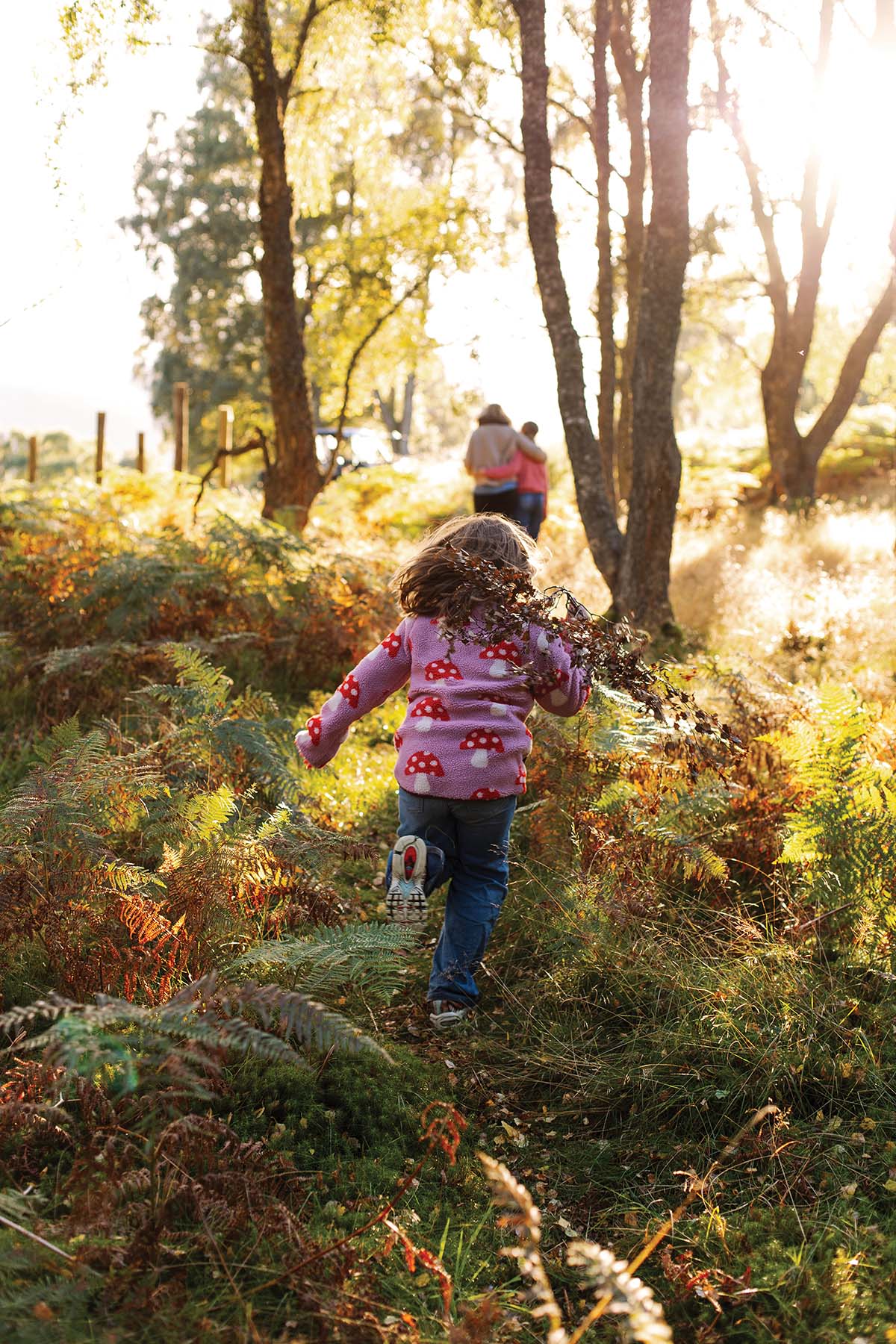 call of the wild, young girls runs through the forest in perthshire scotland