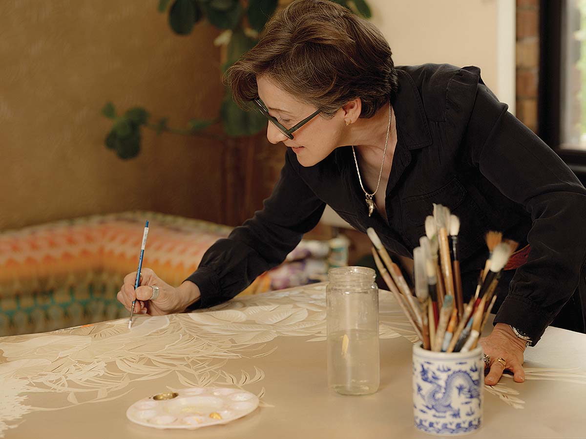 Fromental co founder Lizzie Deshayes hand painting a largescale silk wall covering