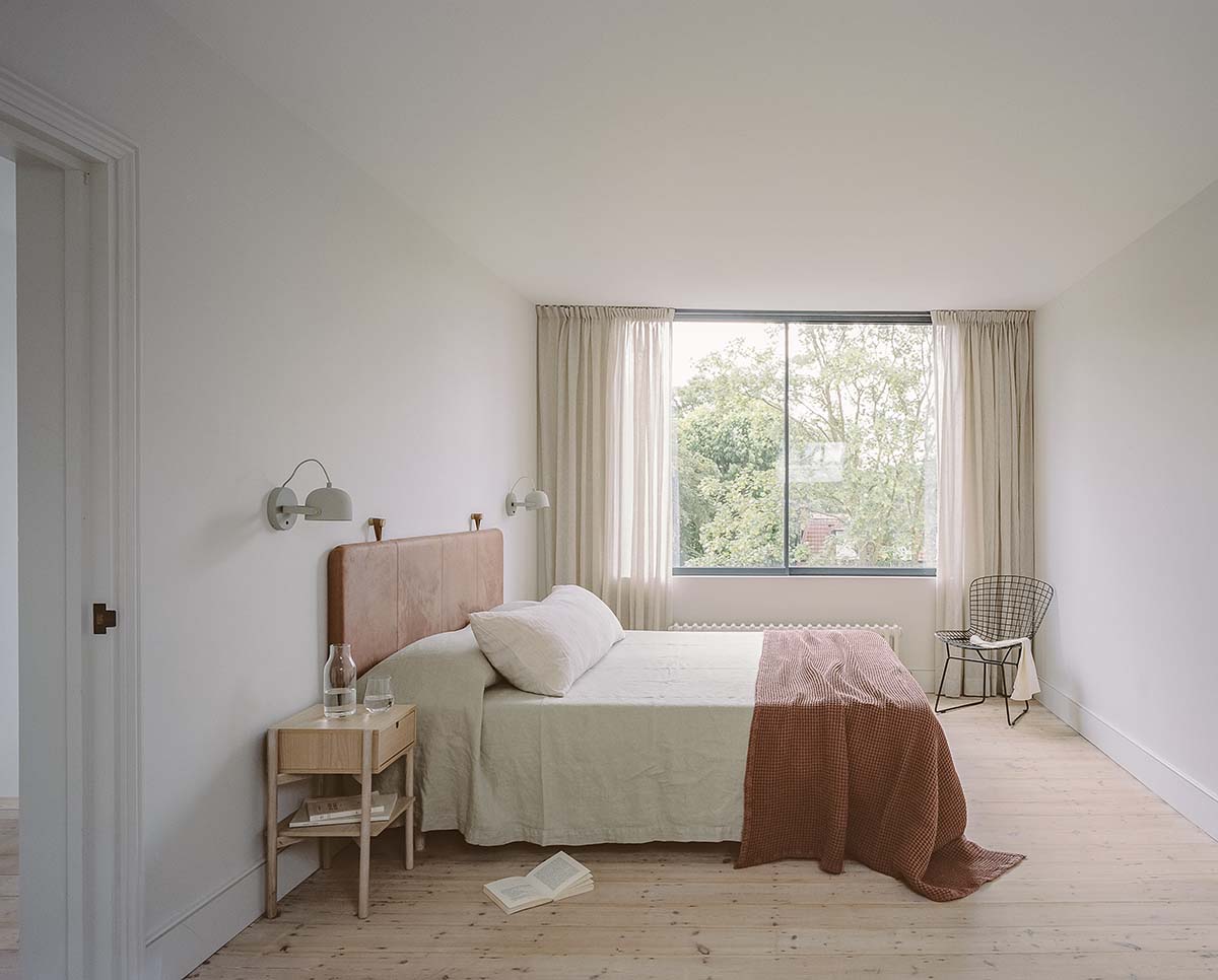 Bindloss Dawes Architects project in London: Lordship School House, photographed by Nick Dearden of Building Narratives. Primary bedroom with pink offsets and garden view