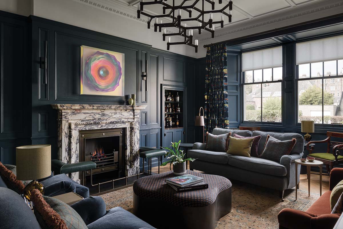 revamped Edinburgh house impressive living room filled with art, a marble fireplace surrounds and blue paneling to offset each zone in the room