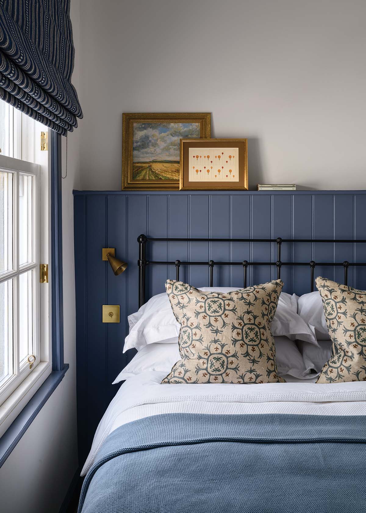 A compact bedroom used by one of the teenagers. “To make it more functional, we added the panelling [painted in Little Greene’s Juniper Ash] which acts as a shelf above, to use for storage or decorative items,” in this elie holiday home