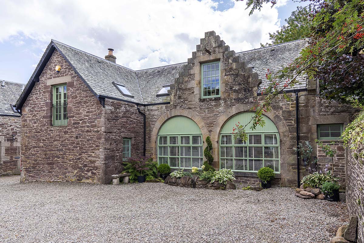 scotlands home of the year 2025 episode four contestants at the carriage house in auchterarder, a victorian conversion in scotland - a cottage with green windowpanes and a gravel footpath