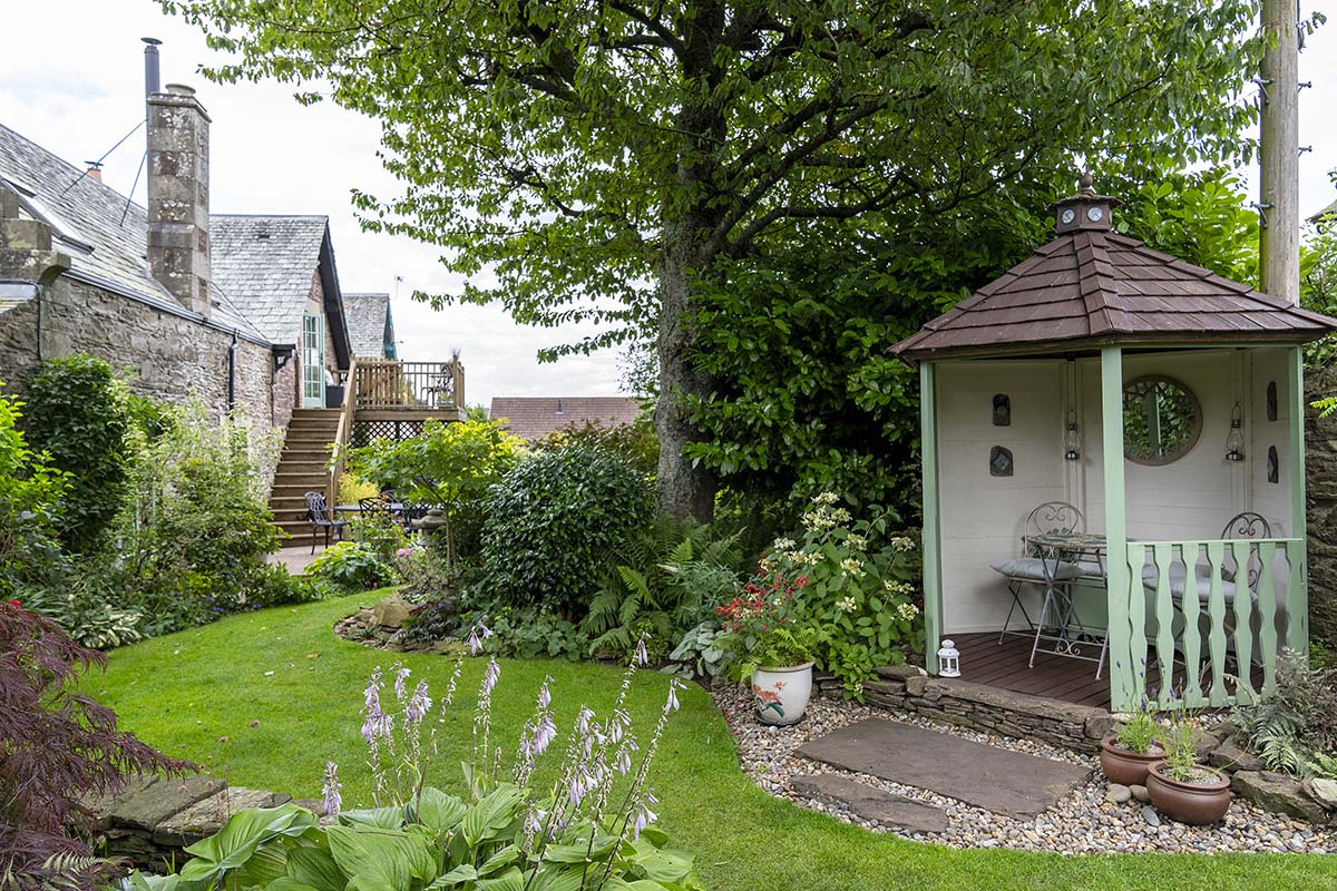 scotlands home of the year 2025 episode four contestants at the carriage house in auchterarder, a victorian conversion in scotland - a cottage with green windowpanes and a gravel footpath