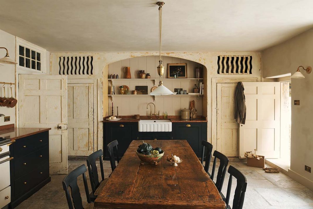 bath townhouse kitchen designed by banjoy beale with exposed stone walls, aga cooker, large dining table in dark wood and inset sink
