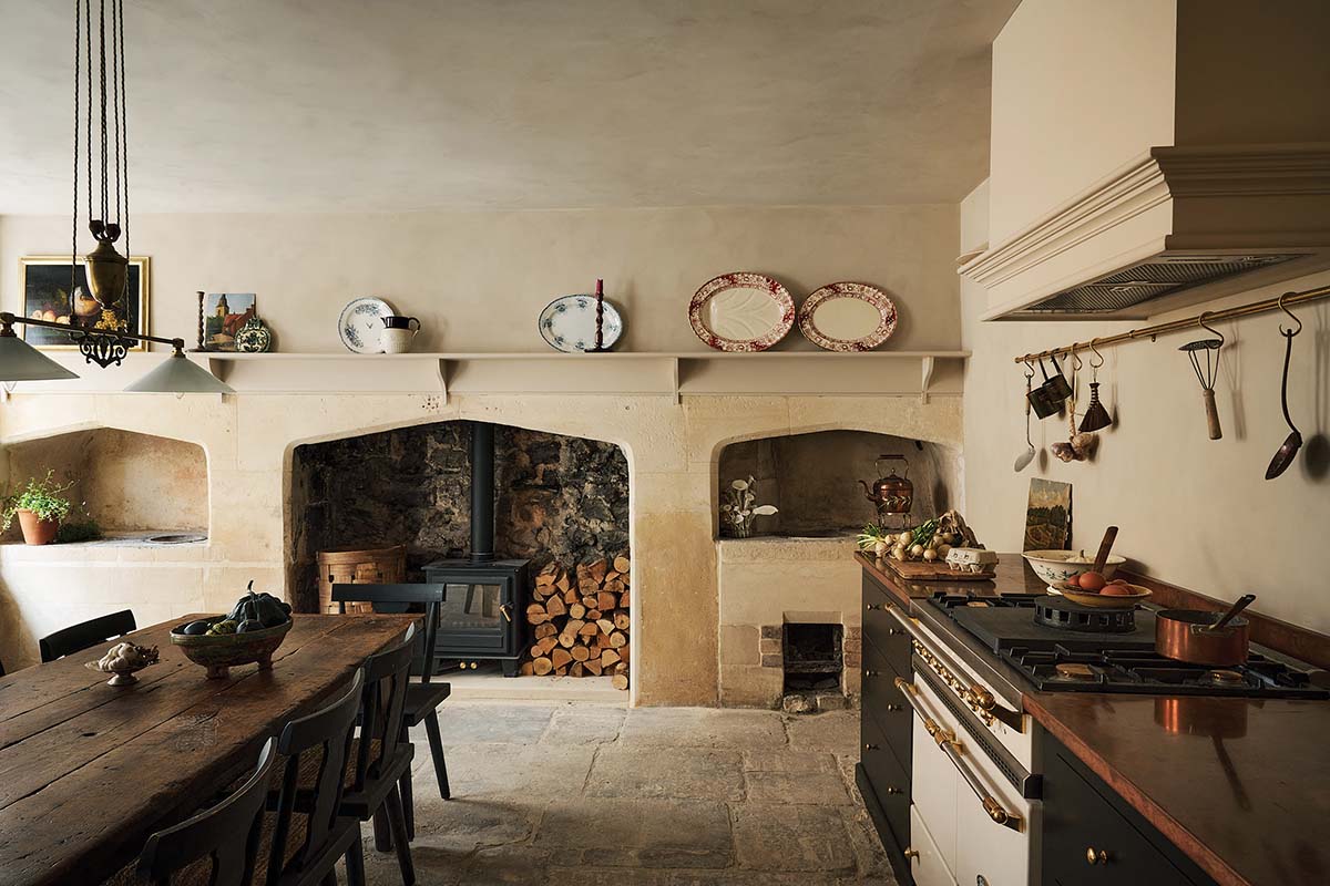 bath townhouse kitchen designed by banjoy beale with exposed stone walls, aga cooker, large dining table in dark wood and inset sink