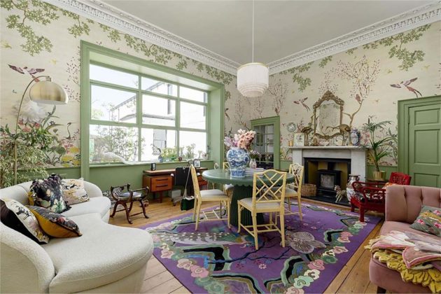 living room with mural walls, pastel green windowpanes, a large purple wendy morisson rug