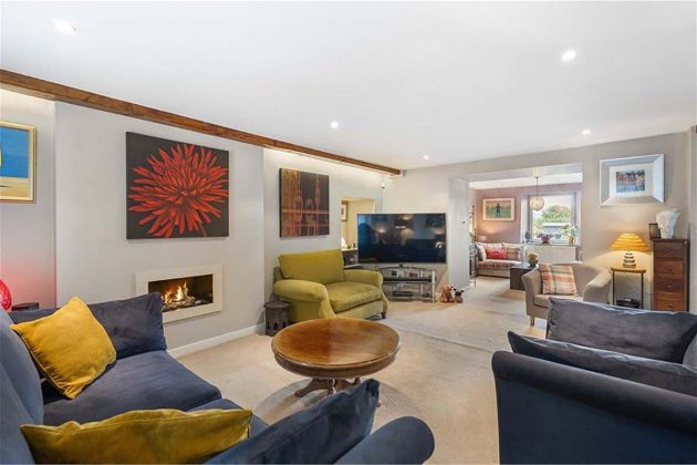 modern living room wuth whte walls, wooden beams, wood coffee table and blue and green armchairs