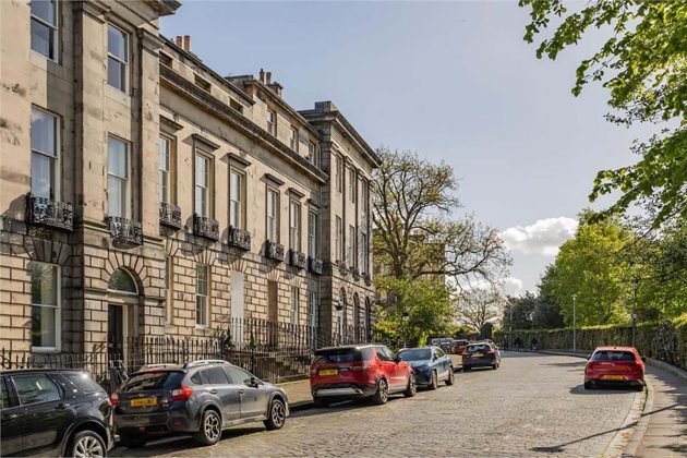 high-end homes for sale in Edinburgh; old tenement flats in edinburgh with trees and cars on the street as well as arched windows and iron fencing