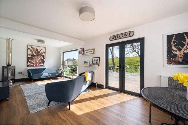 high-end homes for sale in Orchard Wood; laminate flooring in a contemporary living room with patio doors in a house for sale with espc