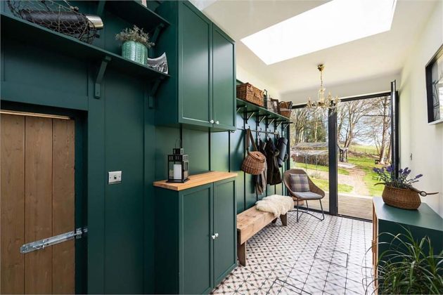 high-end homes for sale in Orchard Wood;; green utility room with wooden bench and gold coat hooks in a house for sale with espc