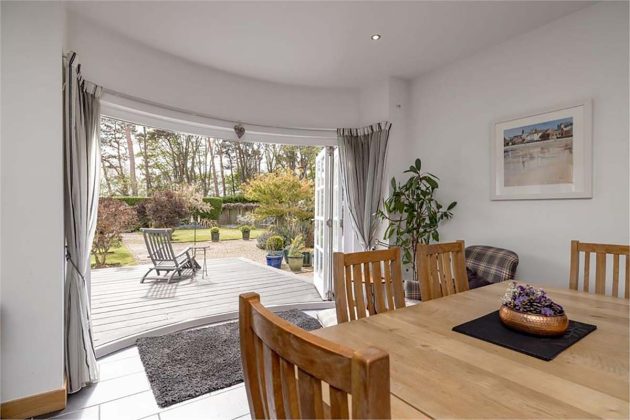 curved patio doors with oak furniture and grey deep pile rugs