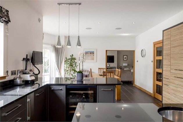 grey and black kitchen with pendant lighting and glossy cabinetry