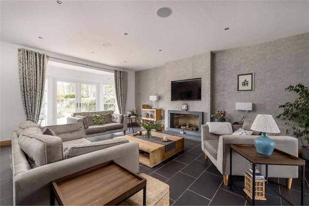 grey living room with black tiled floor and wall mounted tv
