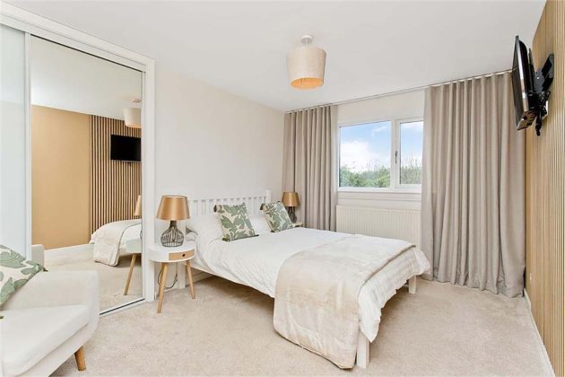 high-end homes for sale in Tanglewood; white bedroom with cream curtains and a white double bed
