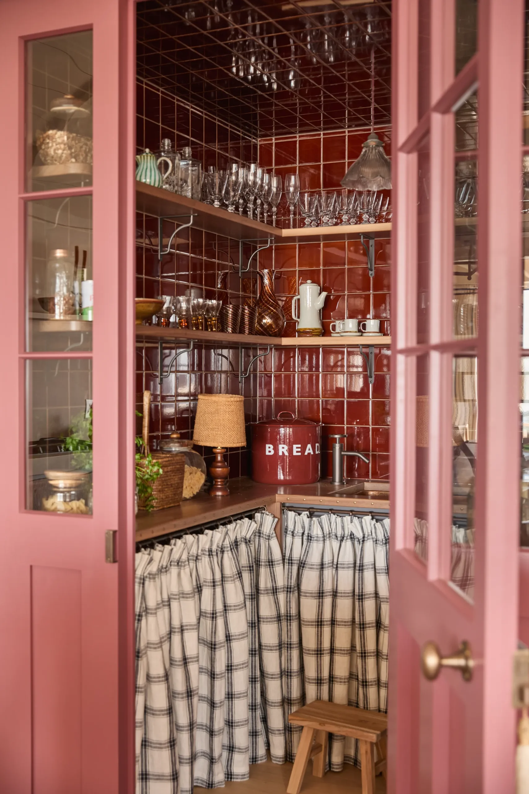 a pink pantry with red tiles and a traditional gingham shelf skirt; pantry ideas for your kitchen