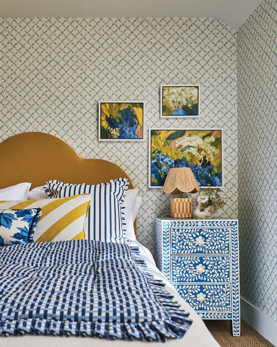 creative bedroom design inpired by the cote d'azur with yellow cabinet, floral blue side table, yellow cushions, blue bedsheet, elegant interiors, blue stripe bedding