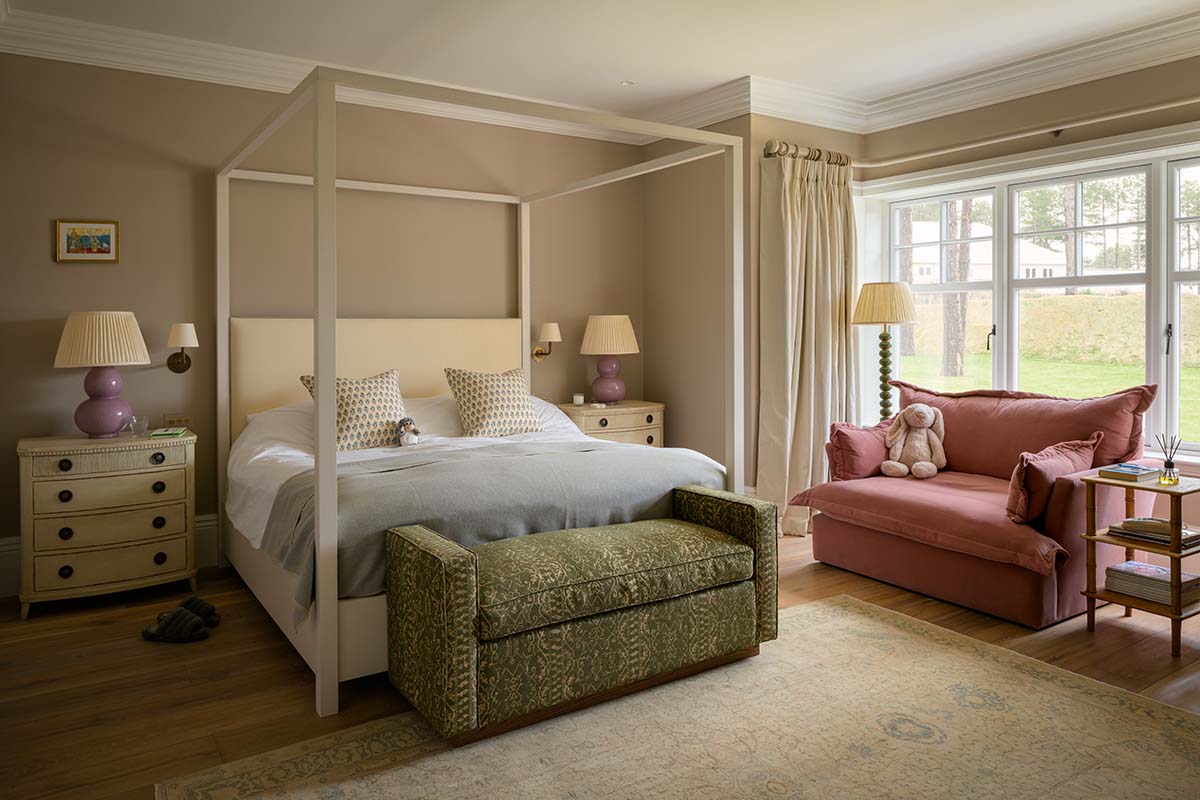 pink-armchair-reading-nook-four-poster-bed-hfloral-room-headboard-green-foot-stool-storage-blue-bed-linens