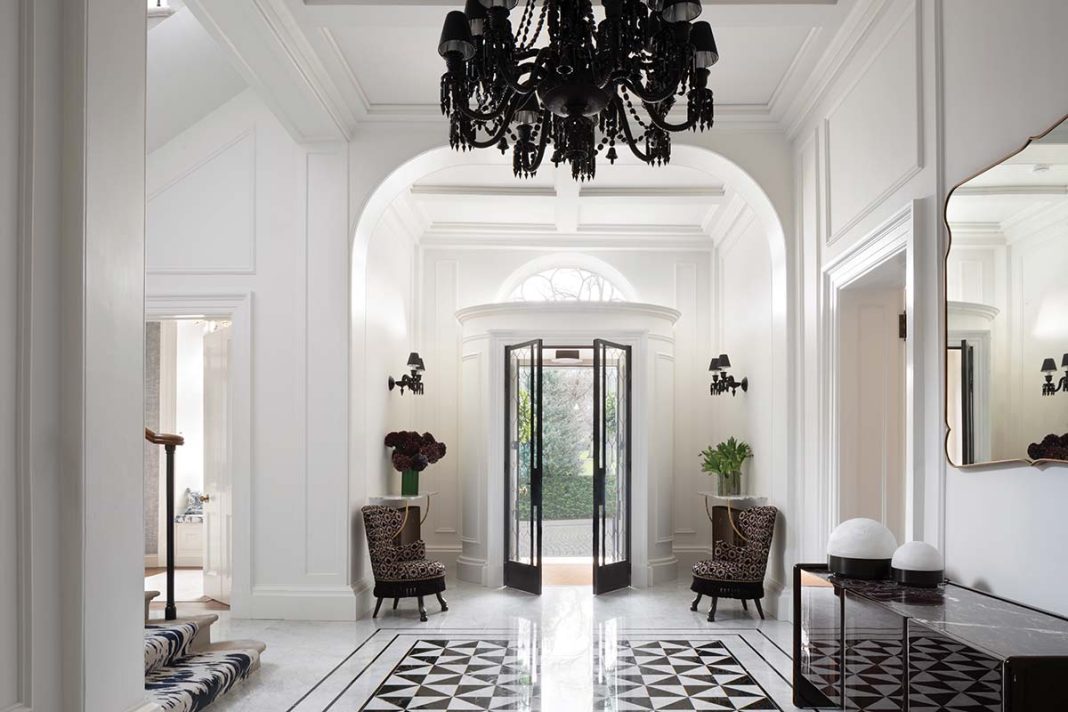 white house with black interior and monochrome layout with checkerboard floor tiles and rugs with black door frame