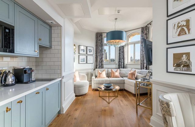 pastel blue kitchen in a high-end edinburgh holiday home with yellow cushions and a reading nook by the window