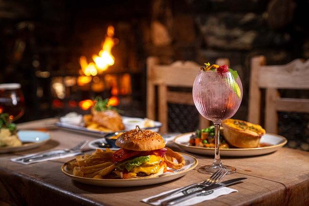 restaurant with a gin cocktail on a wooden table at the oak tree inn on loch lomond, one of Scotland's best luxury hotels, cottages and cabins