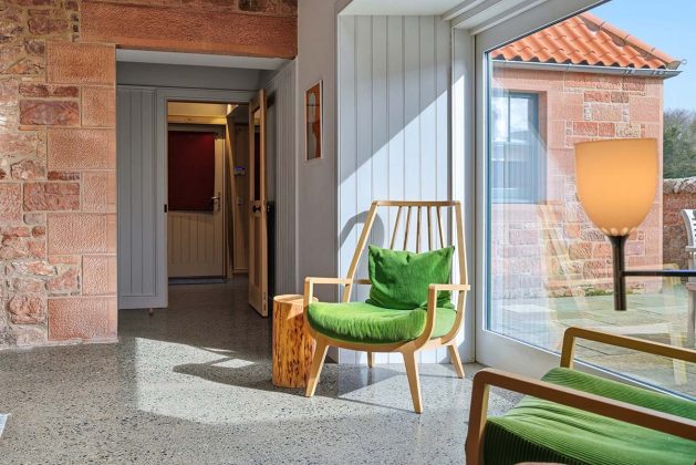 window wall in a scottish farmhouse with green chairs in a reading nook