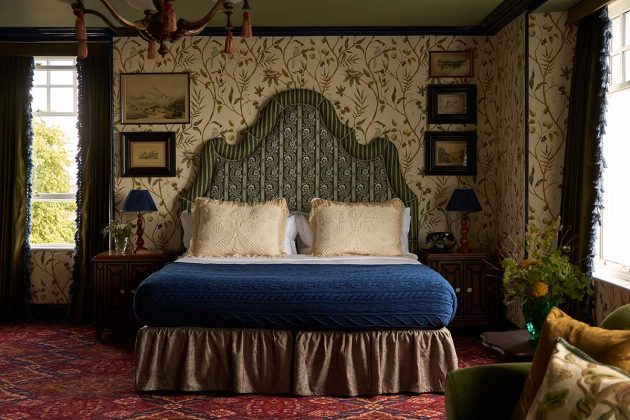 dornoch hotel bedroom with fringes bed and stateent floral headboard and traditional wallpaper, one of Scotland's best luxury hotels