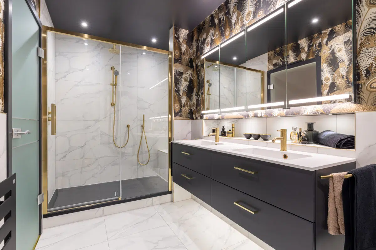 Master en suite renovation in Edinburgh by The Bathroom Company with marble walls and blue vanity cabinetry
