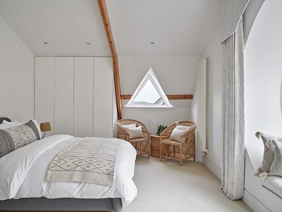 white bedroom; boho bedroom with a triangle window, neutral bedding and white walls