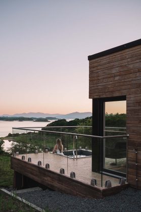 lady looks out of a hotub onto the loch