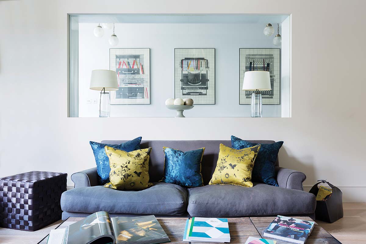 blue sofa with a window wall in the house to see through from kitchen to living room; picture walls for modern homes