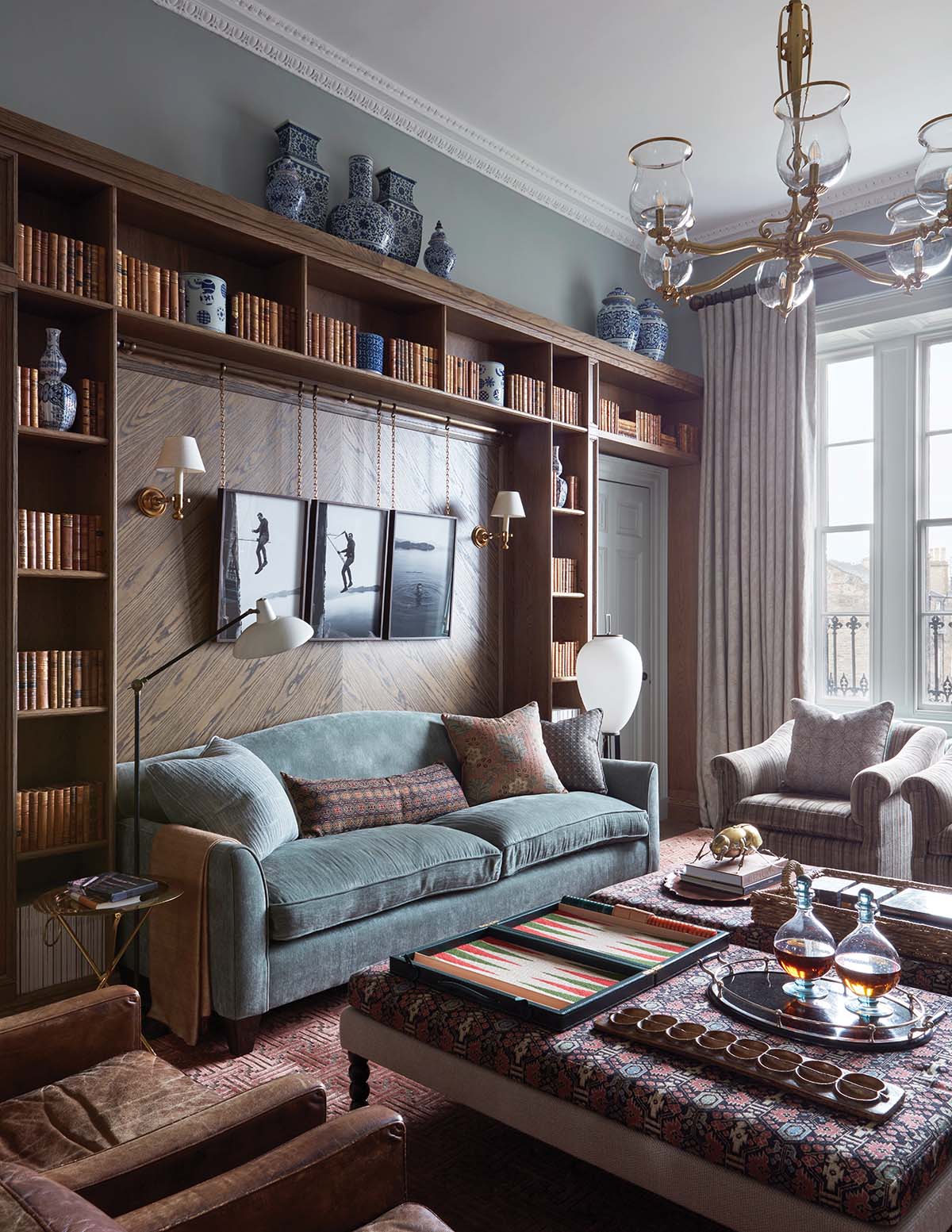 designed by Hubert Zandberg: living room with blue couch and a wall of books