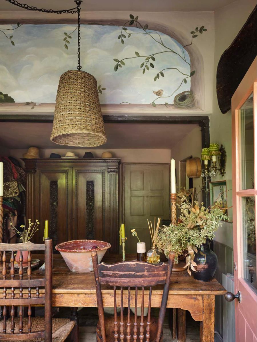 A trompe-l’oeil window scene by painter Queenie Ingrams breathes light into Fiona de Lys dining room