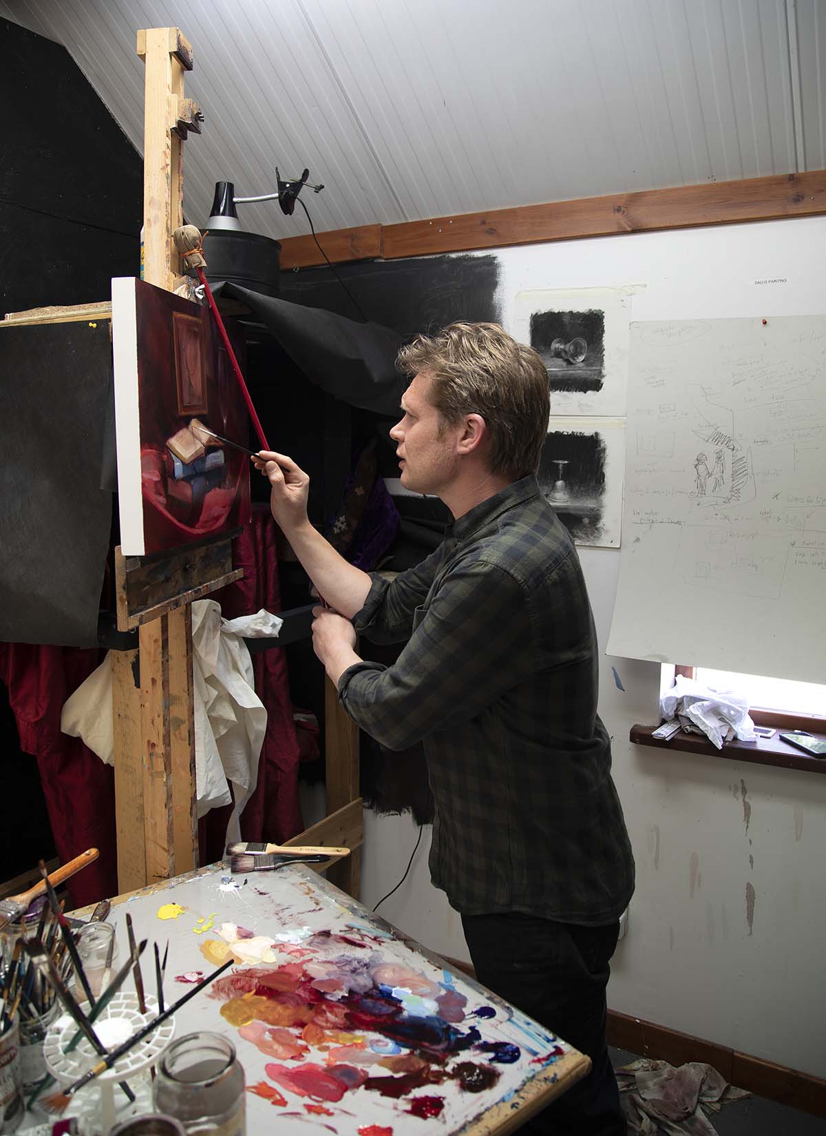 Andrew Sinclair painting in his studio
