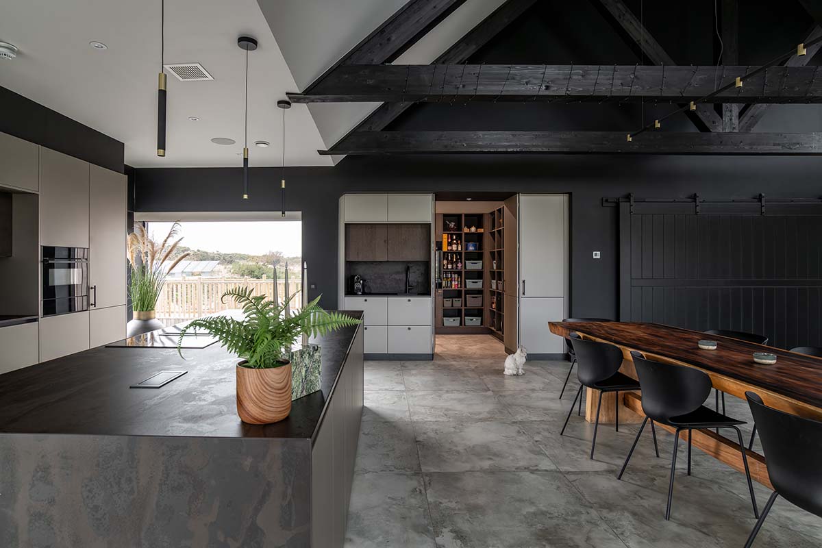 Laings living-dining area project - black wood paneling and white walls, including an oak library