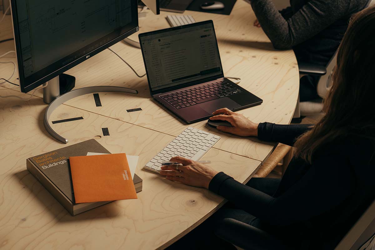 an architect's laptop with working drawingd and house renders