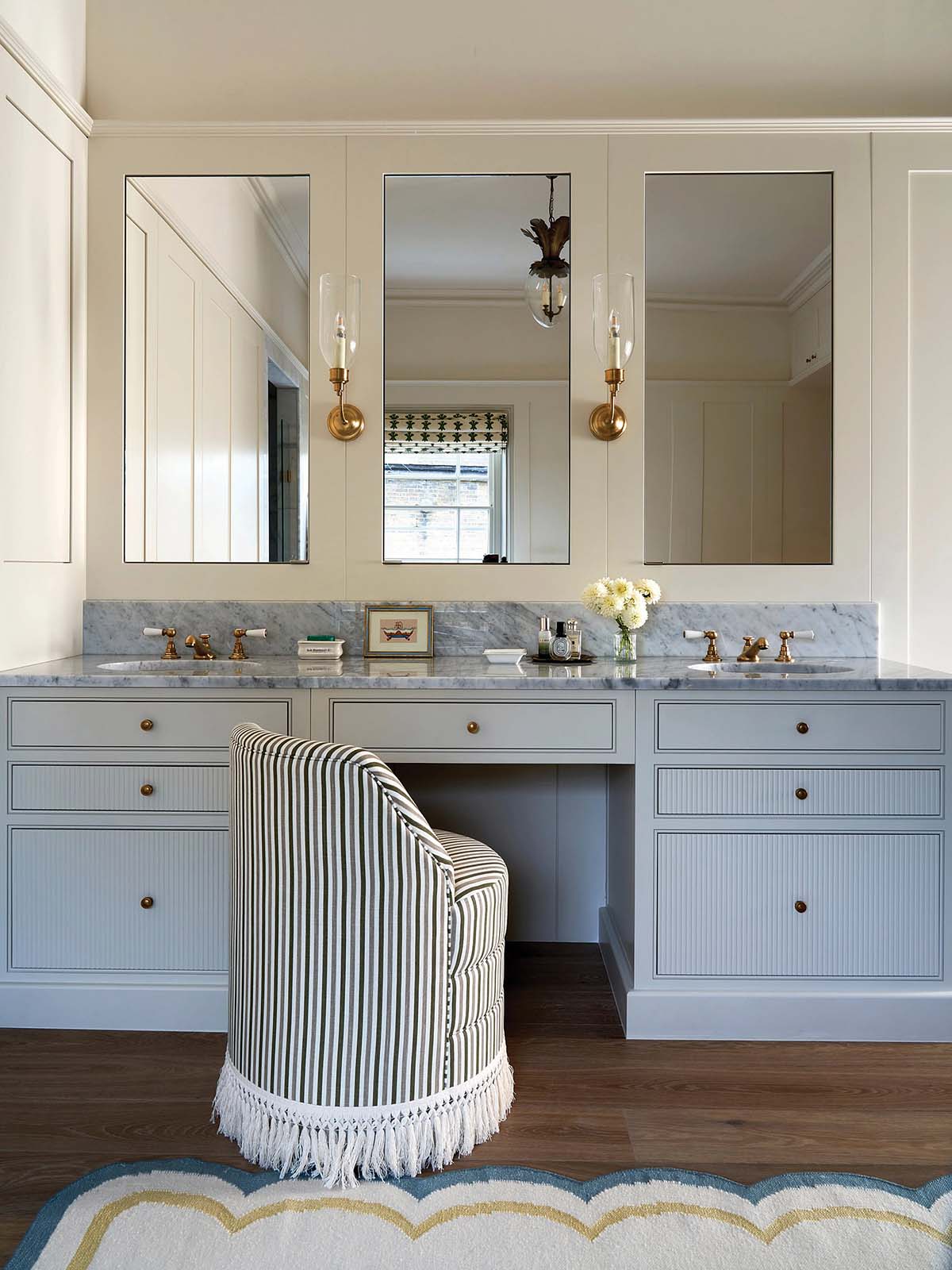 blue vanity room with beauty table and blue cabinetry and striped tassel chair