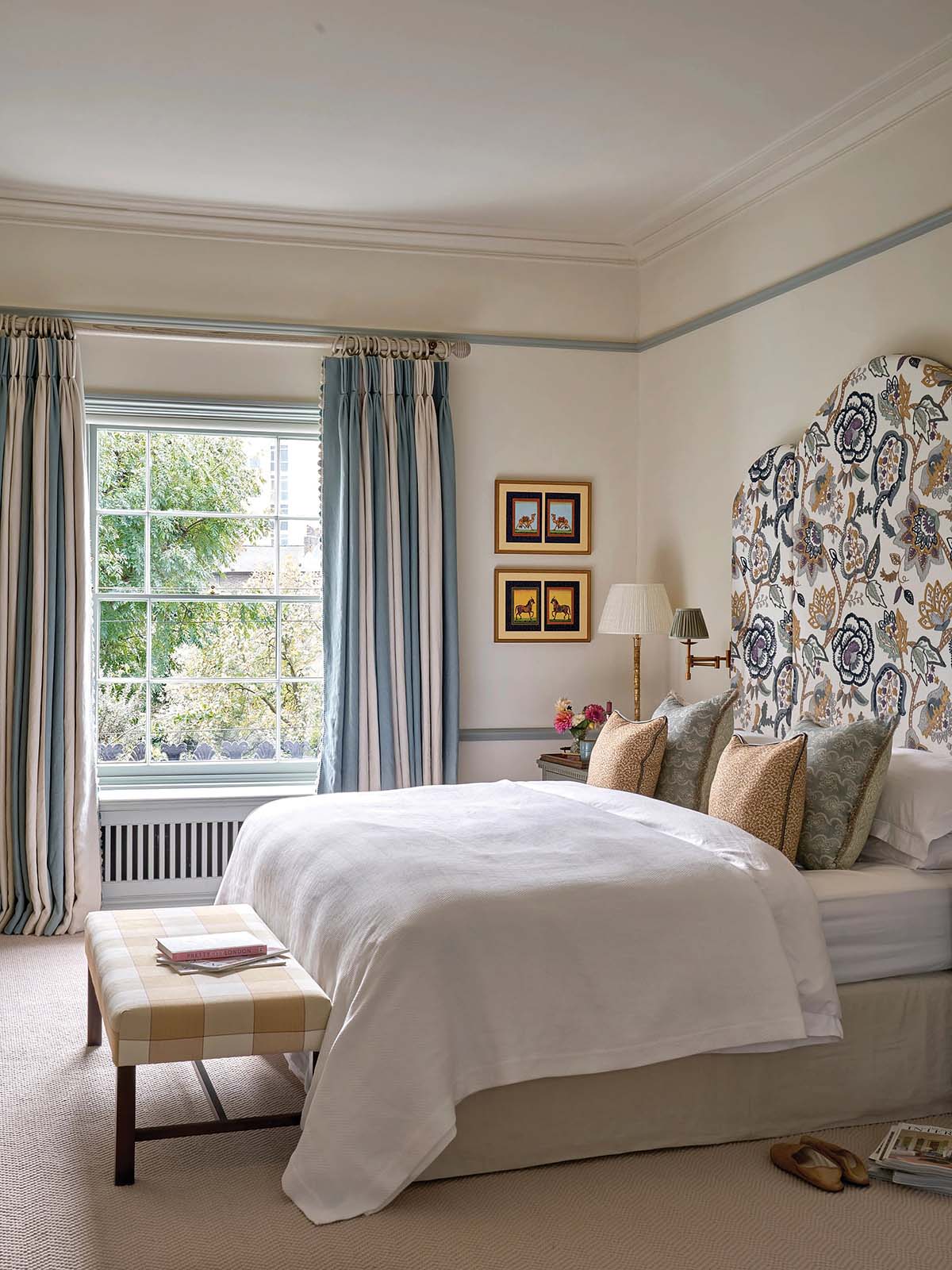pale bedroom scheme with blue headboard and yellow footstool