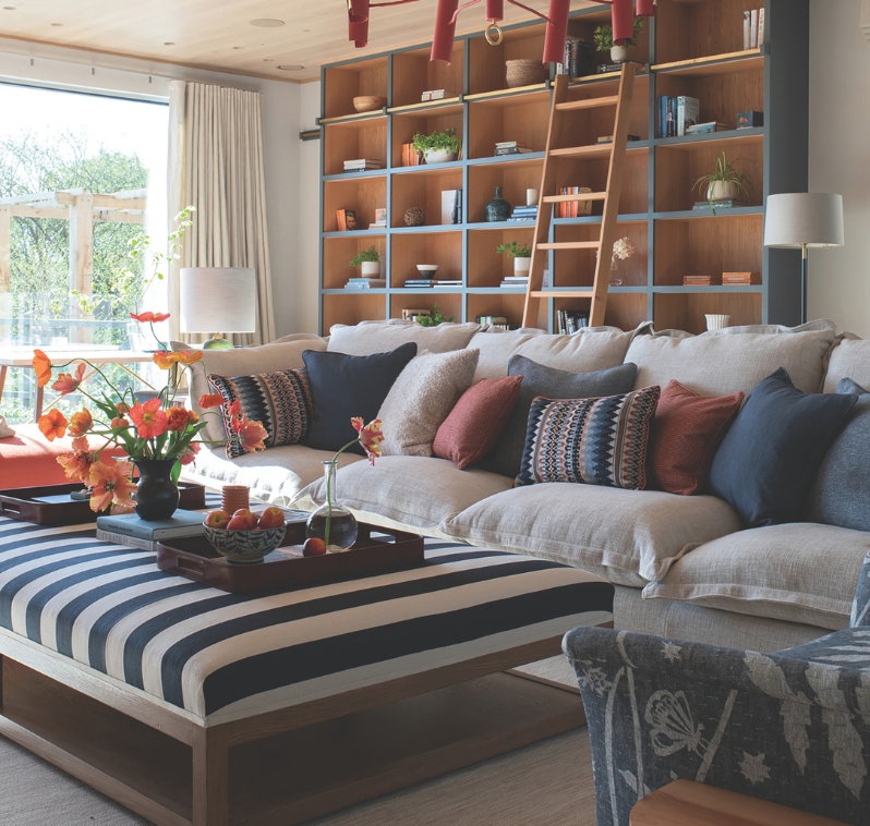 a blue living room with handmade shelves and abstract red ceiling light