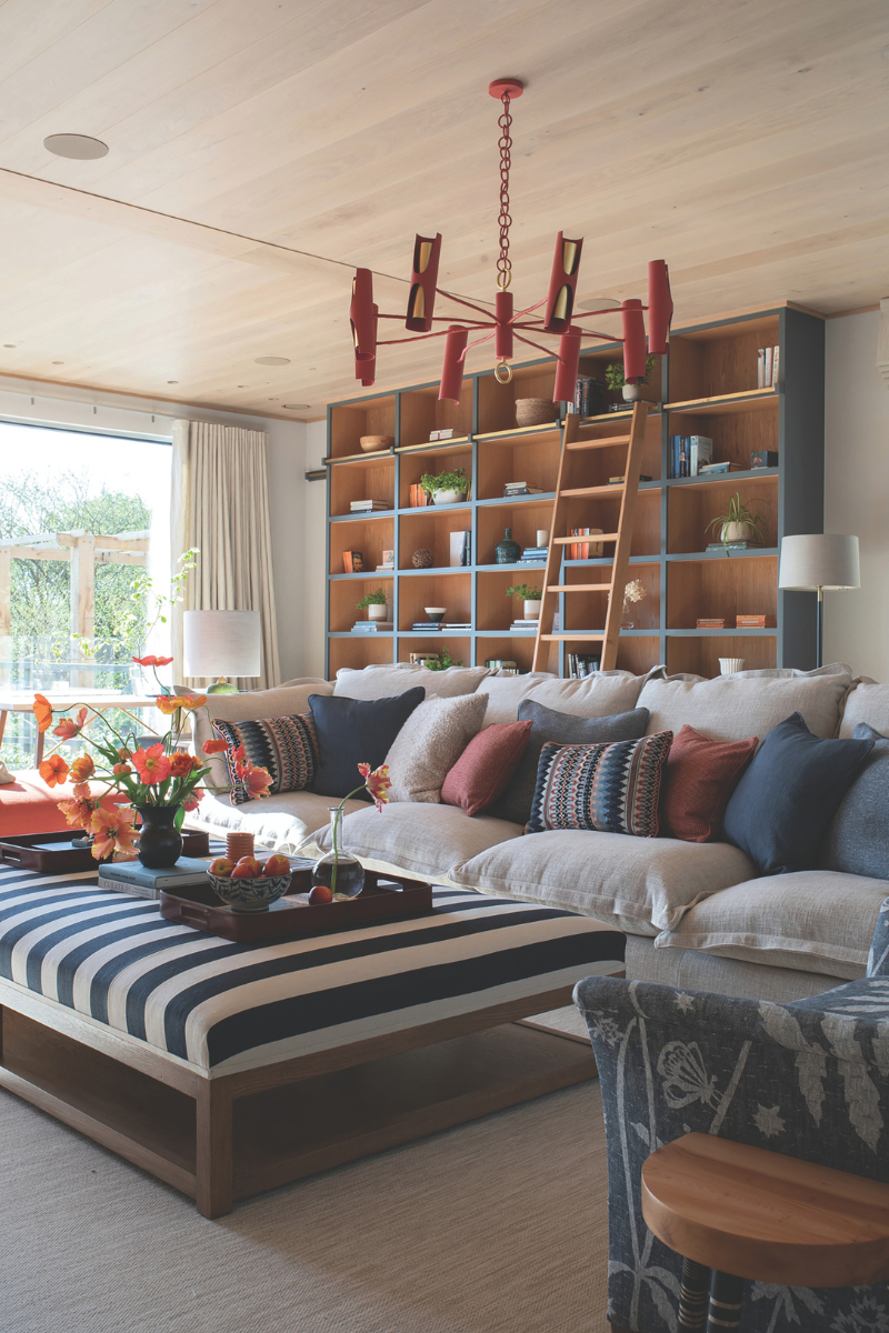 a blue living room with handmade shelves and abstract red ceiling light