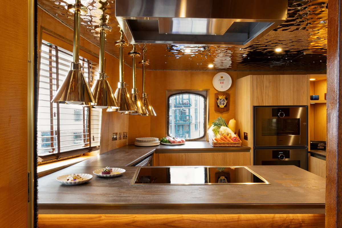 Fingal Hotel new kitchen by kitchens international, with golden lights above the pass and a mini chef's table for guests