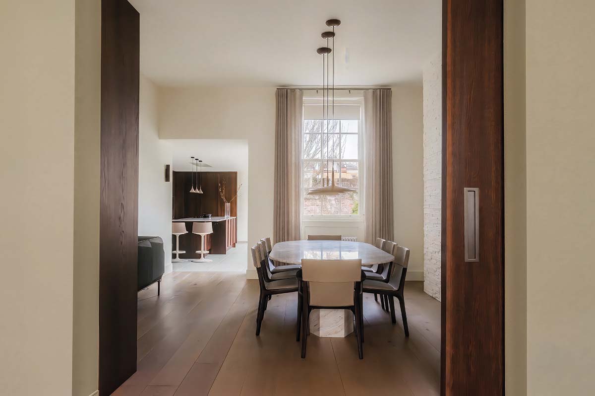 a brown dining room with yellow walls and sleek walnut flooring by studio september and bann