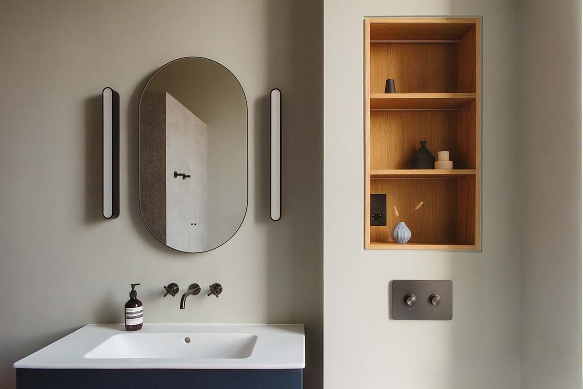 pure white bathroom with round oak mirror and black sink in edinburgh
