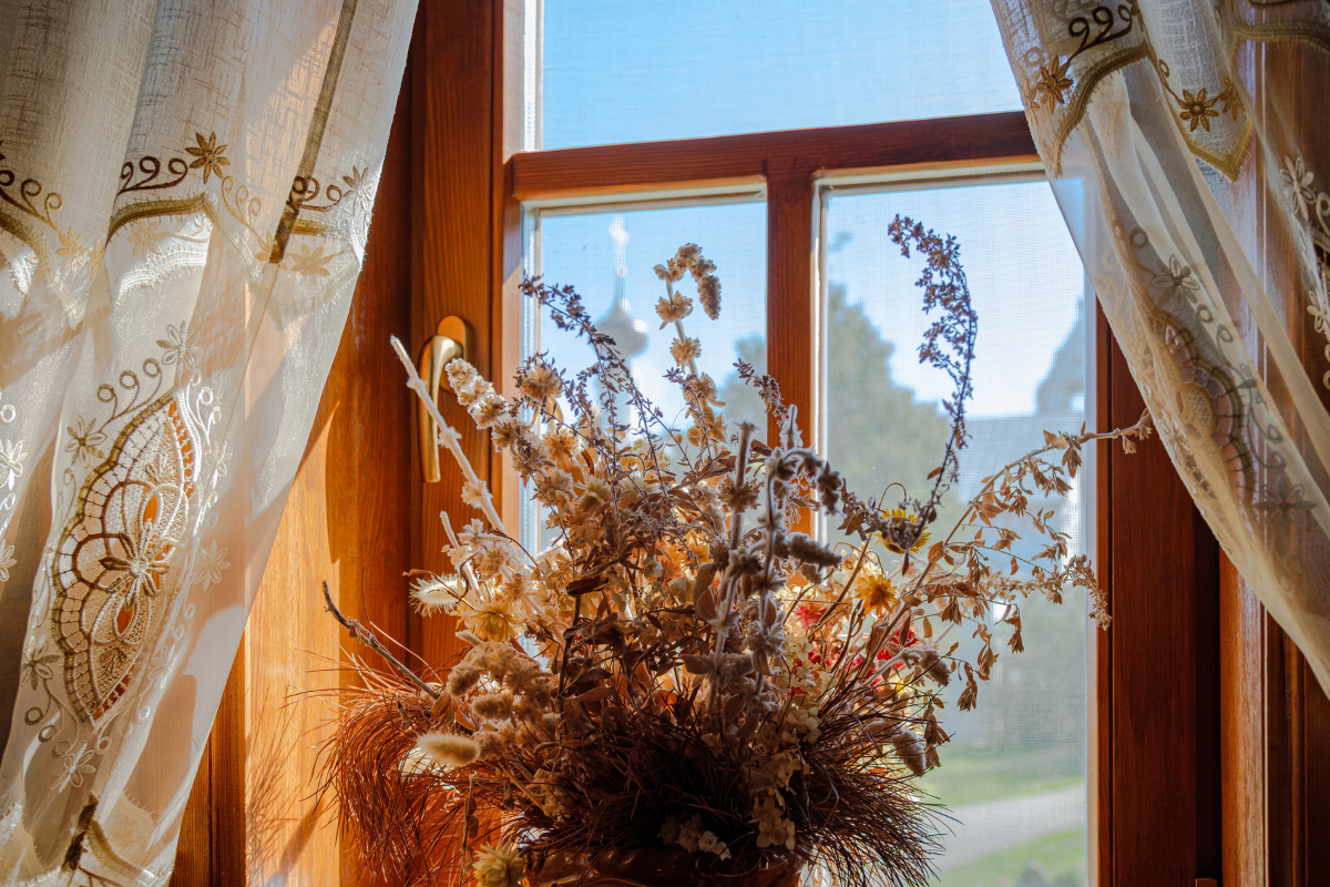 Dried flowers sit in window during spooky season and halloween