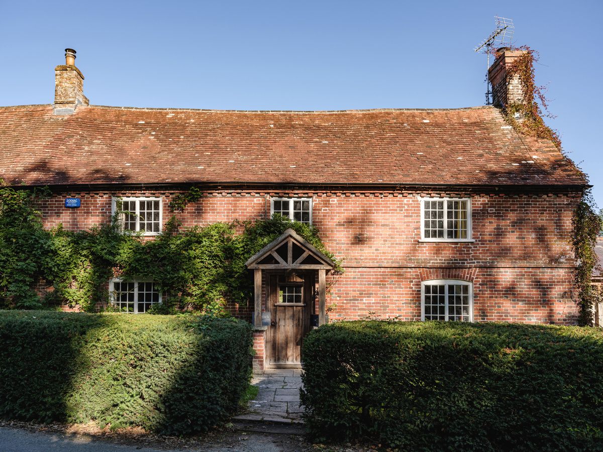 red stone cottage with incredible contemporary extension with vines around the door and wooden pagoda entrance